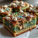 Chewy St. Patrick's Day cookie bars packed with colorful sprinkles and creamy white chocolate chips, baked to golden perfection.