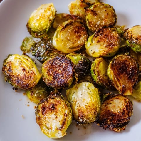 A pan of roasted Brussels sprouts, showing perfect browning, ready to accompany any delicious meal.