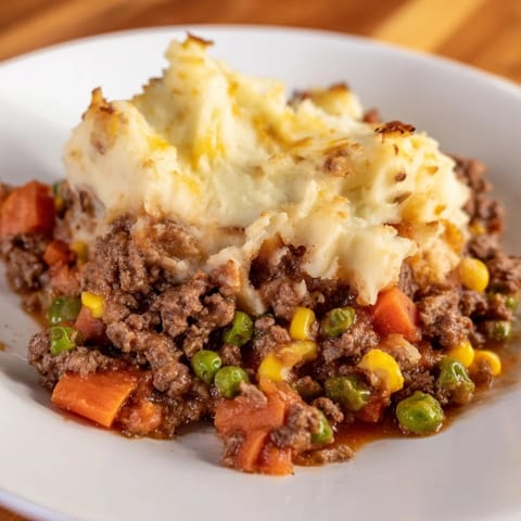 A close-up of Shepherd's Pie: a hearty, comforting casserole with a perfectly golden crust, ready to serve.
