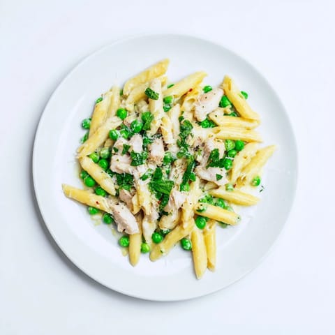 A close-up of Pea & Mint Chicken Pasta garnished with fresh mint and lemon zest.  