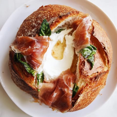 Golden, buttery sourdough slices are filled with crisp prosciutto and melty burrata cheese for a luxurious sandwich.  