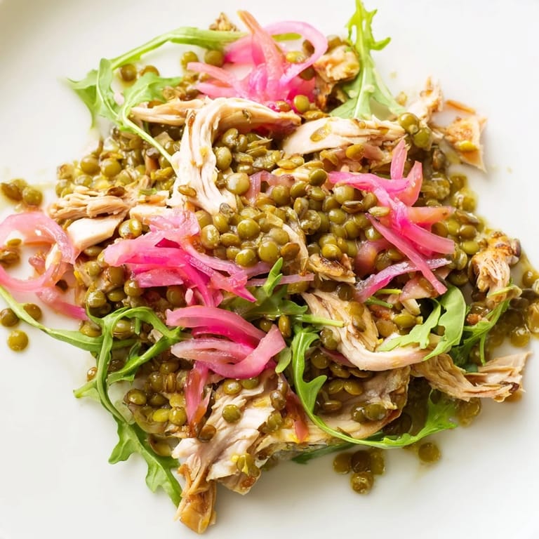 A close-up of the zesty mustard-dressed Lentil & Chicken Spring Salad highlights juicy cherry tomatoes and tangy pickled onions.  