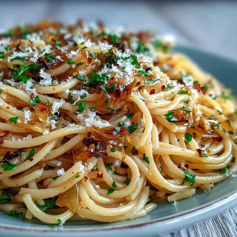Close-up of Cabbage Pasta With Garlic and Parmesan, highlighting strands of spaghetti coated in melted Parmesan and garlic.